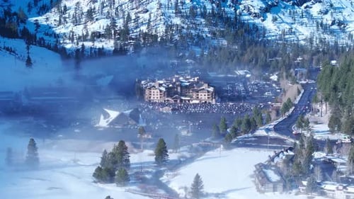 Aerial Winter Resort Village with Fog and Snow Covered Valley in California