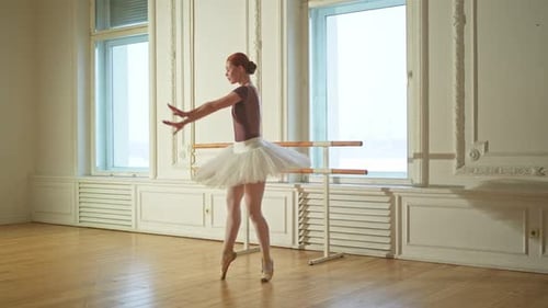 Graceful Ballerina Practices Ballet Routine in Light Studio