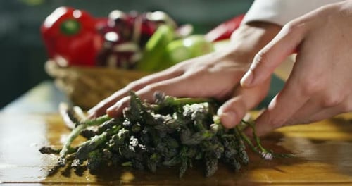 Macro close up slider of fresh juicy asparagus on a wooden kitchen table