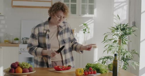 Young Woman Happily Cooking and Dancing in Kitchen