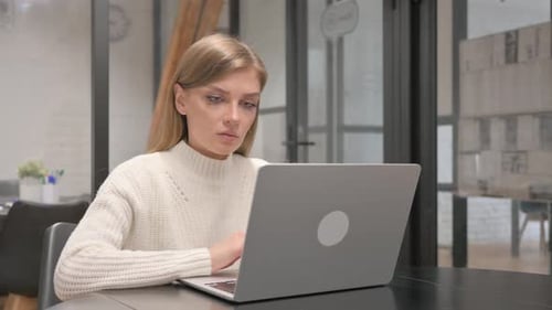Woman Working on Laptop in Modern Office