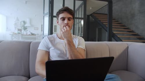 Closeup Young Man Working Laptop Computer At Home Office. Portrait Of Focused Businessman Thinkin...