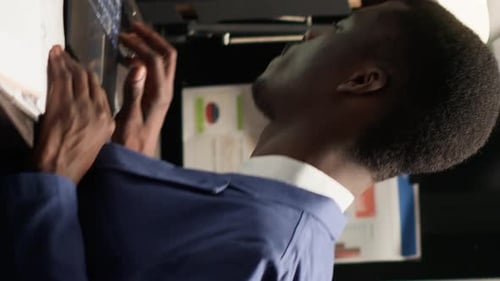 Man in Suit Reviews Financial Data on Screens