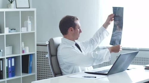 Professional Medical Doctor Working in Hospital Office Using Computer Technology