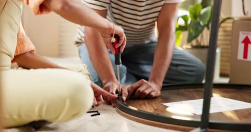Couple, assemble table and move in to new home for renovations, relocation and furniture building