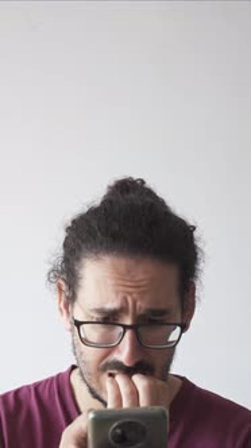 Worried Man Looking at His Phone
