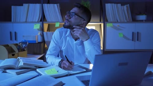 Focused Young Adult Working Late at Desk