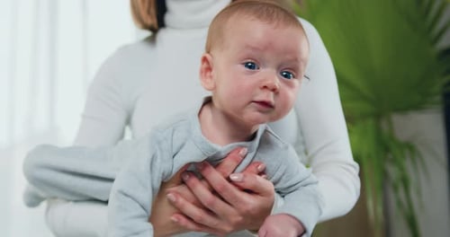 Mother Holds Adorable Infant in Close Up Shot