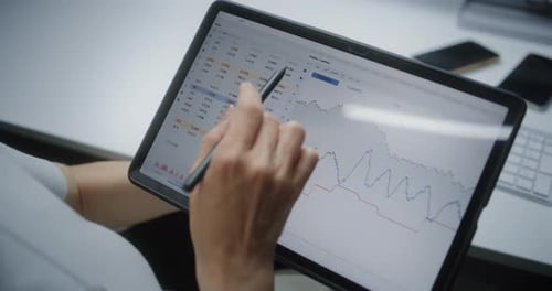 Woman Analyzing Charts on Digital Tablet