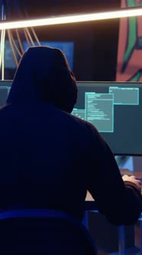 Vertical Video Hooded Man in Underground Hideaway Hacking Computers