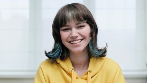 Headshot Portrait of Young Female Looking at Camera on White Window Background