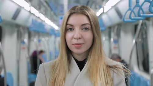Retrato de mujer joven de pie en el metro mirando al pasajero de la cámara