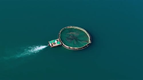 Motor pushing an Offshore Fish Farm Circular Sea Cage in Open Water, Aerial