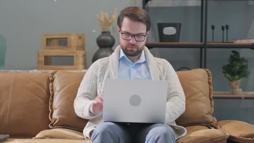 Man Closing Laptop and Leaving Sitting Room at Home