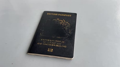 POV close up of a man holding a British passport travel identification document UK damaged bad