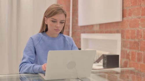 Young Woman Leaving Office after Closing Laptop
