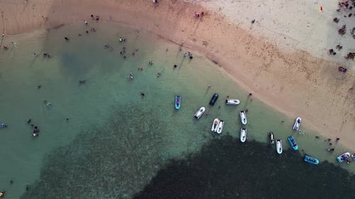 Overhead Drone Shot Showing People Swimming Near Boats in Shallow Beach Water in Nusa Dua