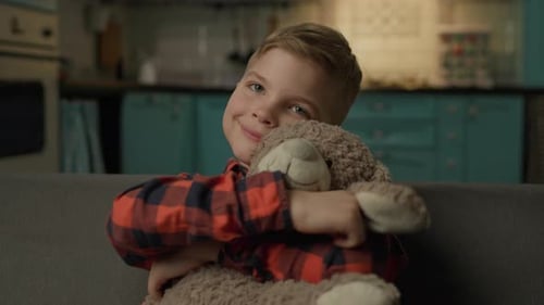 Happy Child Hugging Stuffed Animal on Couch