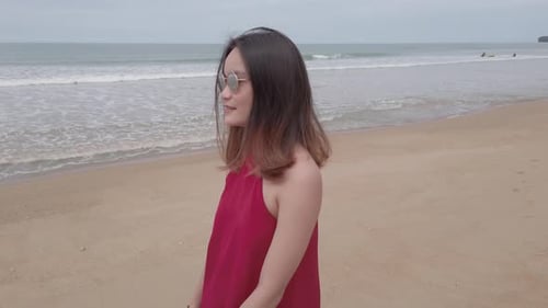 Young asian woman wear red dress and walking relaxing on the beach at summer vacation holidays in sl