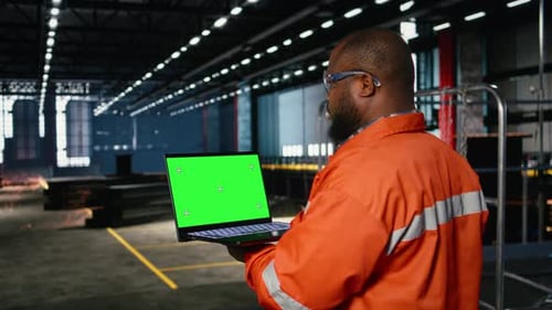 Green Screen Next to Operator Using Laptop and Industrial Equipment