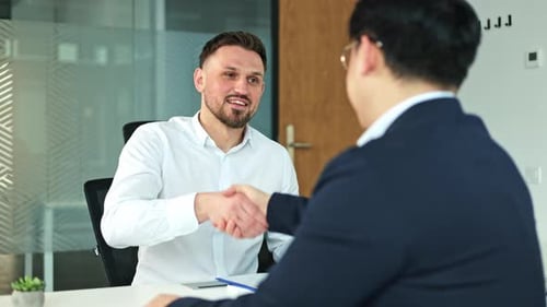 Businessmen Shaking Hands and Discussing Business in Modern Office Meeting