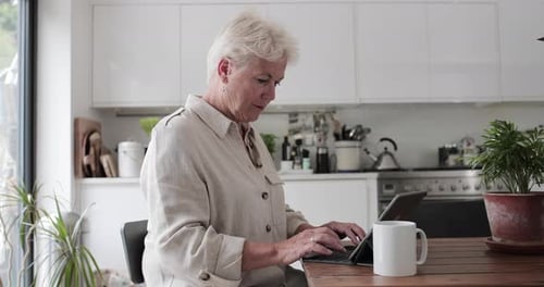 Woman Uses Tablet in Modern Kitchen