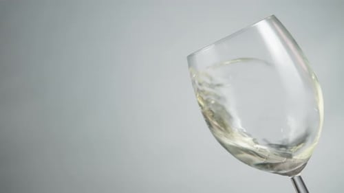 Vin blanc tourbillonnant dans un verre à vin