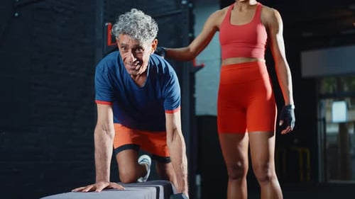 senior man training in the gym with his coach and personal trainer.