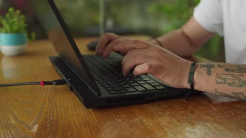 Tattooed Hands Type on Laptop Keyboard Coding Session By Developer Work Process in Tech Program