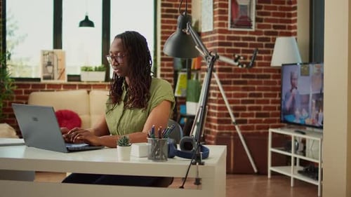 Glücklicher junger Mitarbeiter, der zu Hause auf dem Laptop im Internet surft