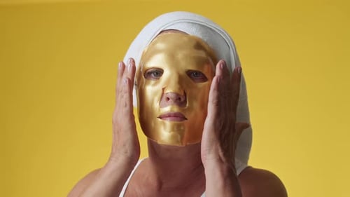 Woman with Applied on Face Sheet Mask on Yellow Background