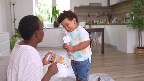 Boy singing karaoke with a toy microphone indoors