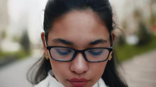 Close-Up of Young Woman with Glasses Looking Up