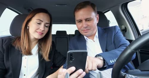 Office Worker Sits in Car and Shows to Colleague Phone Screen