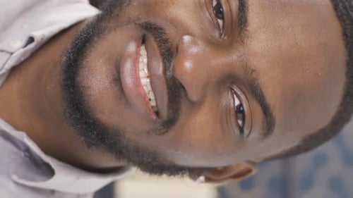 Vertical Video of Close-up facial expression of black man. He is an office worker.
