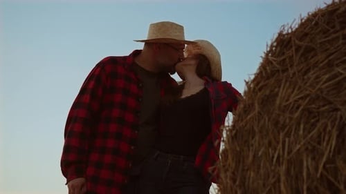 Romantic Happy and Hugging Young Couple Sharing Beautiful Moment at Round Straw Bale