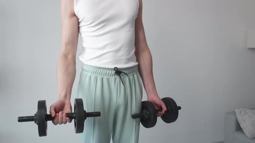 Young Adult Exercising with Dumbbells at Home