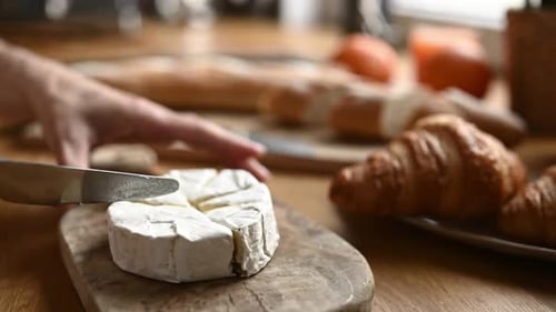 Slicing a Wheel of Brie at Breakfast