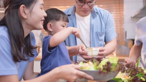Family Preparing Salad Together in Bright Kitchen