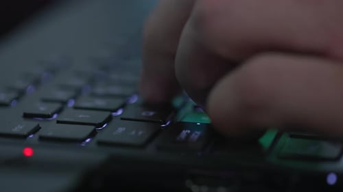 Detailansicht einer männlichen Hand, die eine Laptop-Tastatur tippt