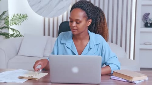 Woman Works at Desk with Laptop in Home Office