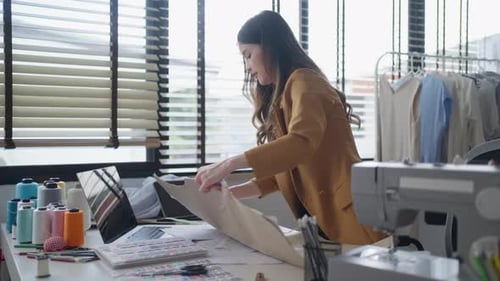 Woman Designs Clothing Pattern in Bright Studio