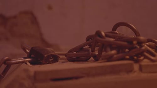 Metal Chain and Lock with a Rusty Link Rocks Flickering Electric Light in Abandoned House Horror