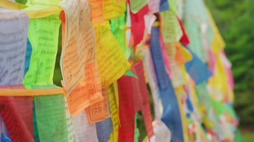 A vibrant row of multicolored Tibetan prayer flags flutters in the breeze, each inscribed with sacre