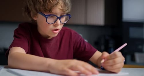 Konzentrierte Jugendliche üben Schreibkunst Ruhig junger Mann übt fleißig Handschrift am Schreibtisch