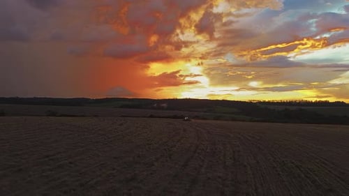 Sunset Aerial View of Tractor on Farm Field