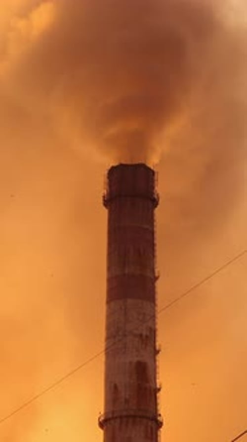 Environmental disaster. Chemical puffs of smoke from factory chimneys pollute the air at sunset.