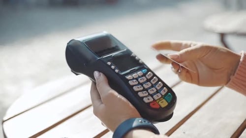 Woman Taps Credit Card on Payment Terminal