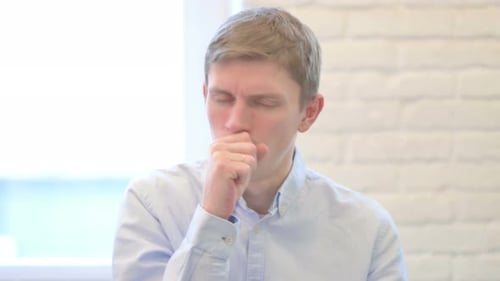 Young Adult Man Coughing Into Hand Close Up