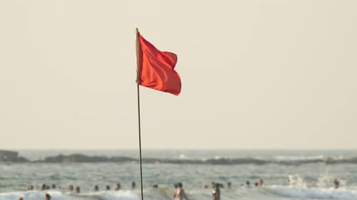 Red Flag Waving on a Sandy Beach